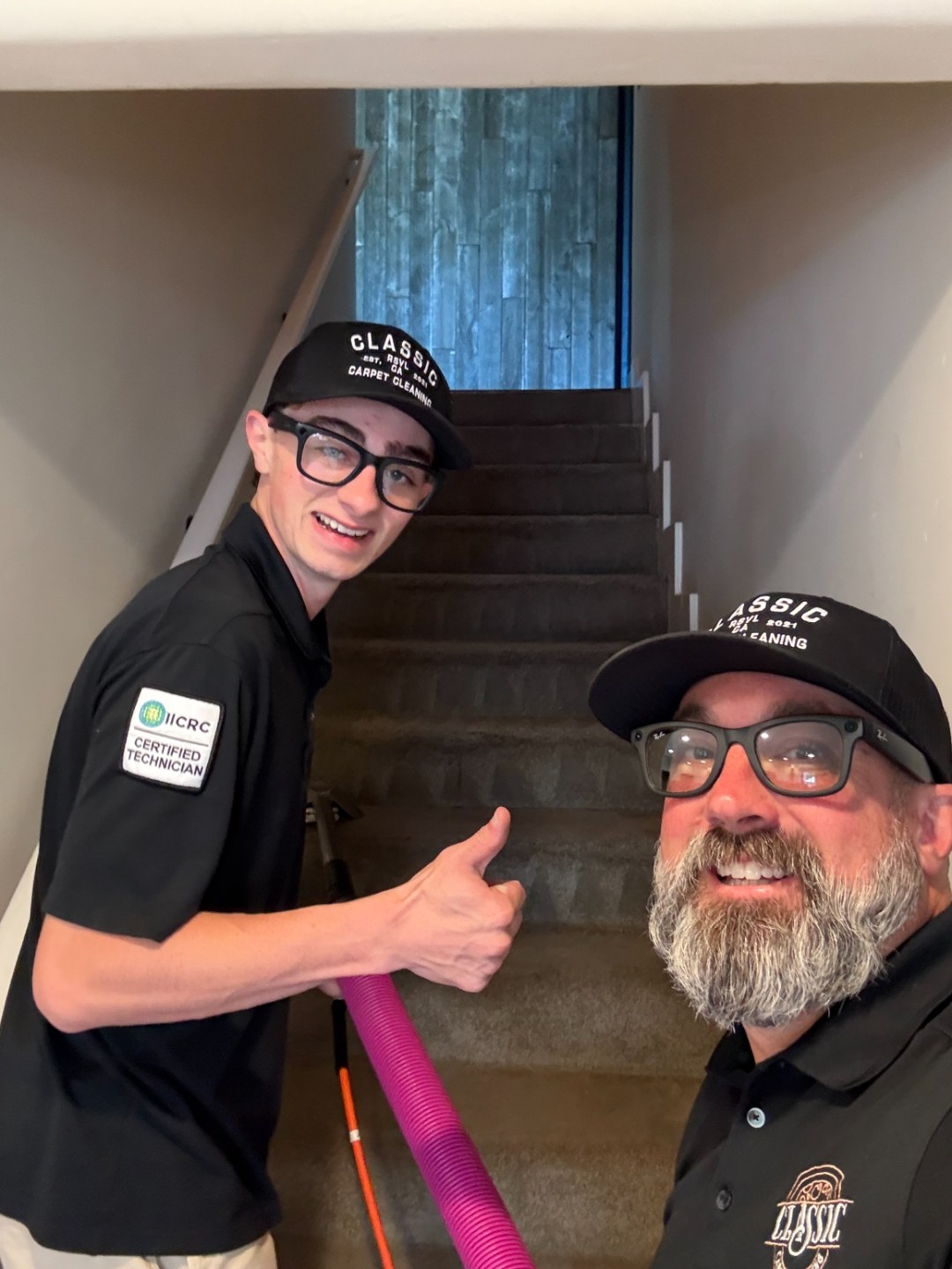 Two Classic Carpet Cleaning technicians giving a thumbs up on a staircase job site