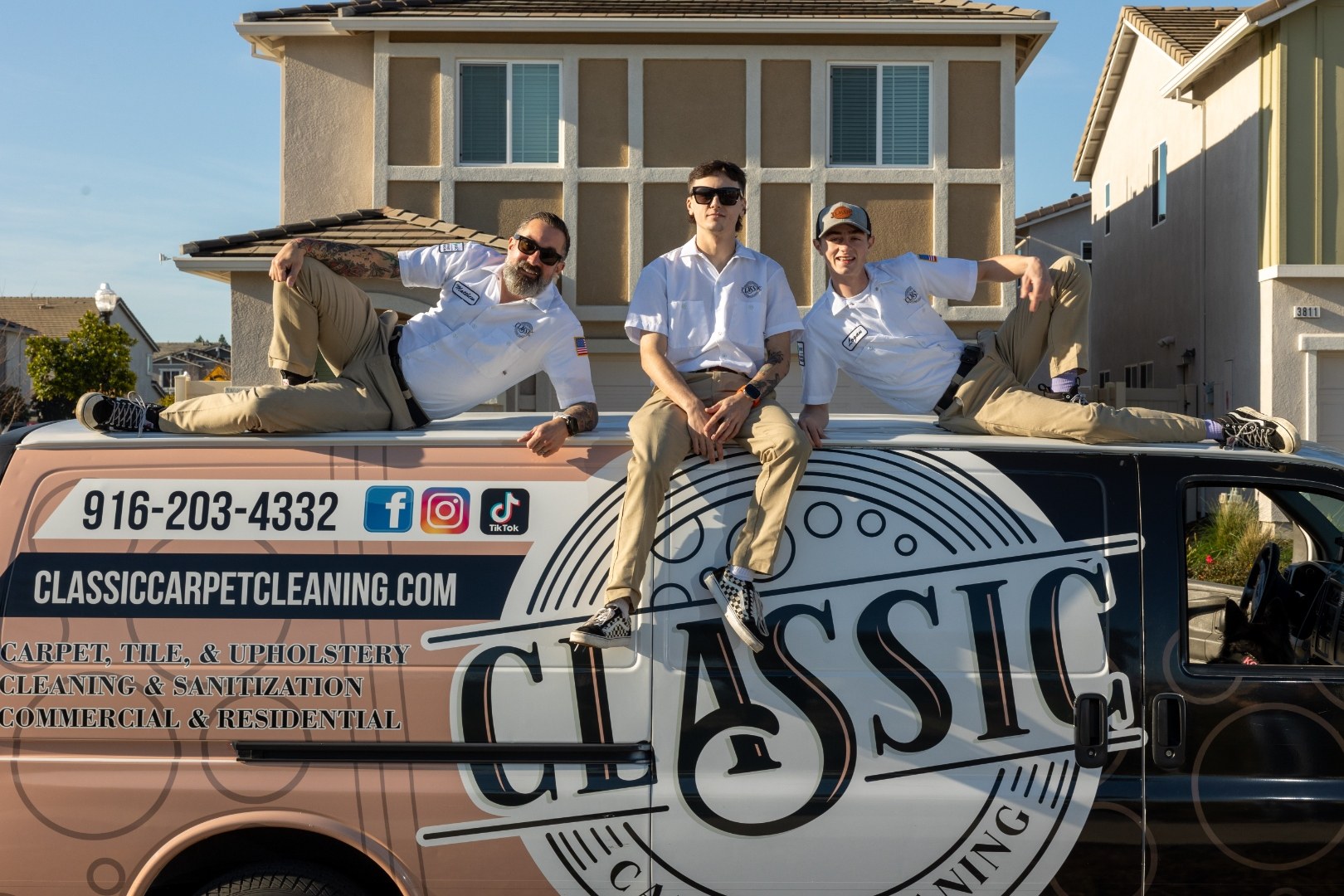The Classic Carpet Cleaning crew sitting on the roof of their branded service van