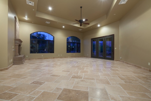 Large travertine tile floor with clean grout lines in a spacious living room
